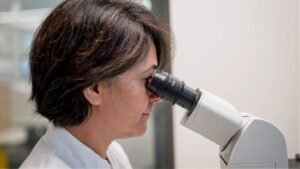Laboratory researcher using microscope at Evelina London Children's Hospital.