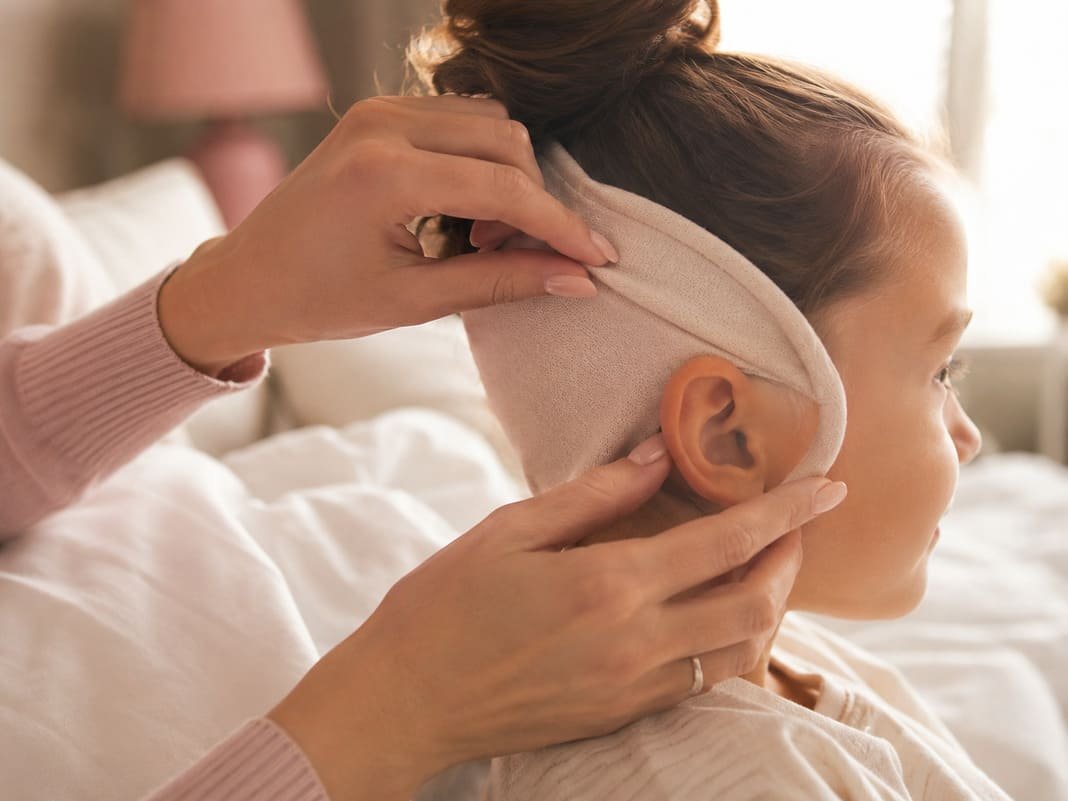 A child wearing a soft headband after ear correction surgery
